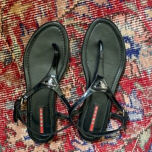 Prada t-strap patent leather flat sandals in black for women